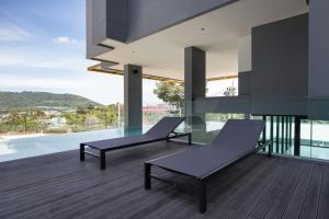 une maison avec deux chaises et un balcon avec vue dans l'établissement New Studio with Disability-Friendly Features, Central Hill View A6-724 A, à Ban Ket Ho