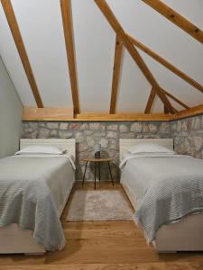 2 bedden in een zolderslaapkamer met houten balken bij Green Forest in Žabljak