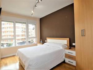 a bedroom with a white bed and a window at apartamento gran bilbao II in Barakaldo