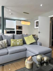 a living room with a blue couch with yellow pillows at The Old Reading Brewery in Reading