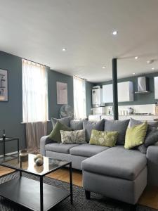 a living room with a gray couch and a table at The Old Reading Brewery in Reading