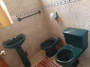 baño con aseo verde y lavamanos en ArenaNorte en Pimentel