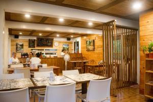 a restaurant with tables and chairs and people in the background at Bernardo's Lantia Hotel in Basco