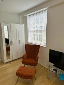 un salon avec une chaise et une télévision dans l'établissement New 2A Soho Studios by Indigo Flats Sleeps 4, à Londres