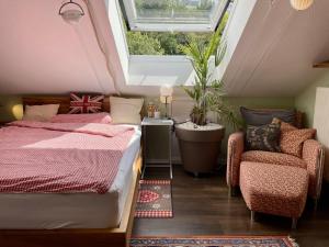 a attic bedroom with a bed and a chair at Guest Room in Stuttgart-Nord in Stuttgart