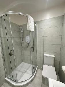 a shower stall in a bathroom with a toilet at New 2A Soho Studios by Indigo Flats Sleeps 4 in London