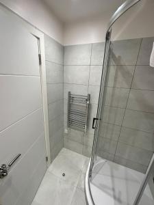 La salle de bains est pourvue d'une douche avec une porte en verre. dans l'établissement New 2A Soho Studios by Indigo Flats Sleeps 4, à Londres