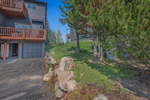 a house with a balcony and a yard with trees at 1032 Luxury Eaglepointe Townhome in Steamboat Springs