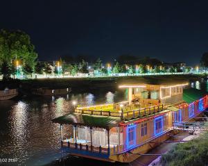 un barco está atracado en un río por la noche en Houseboat Karima palace, en Srinagar