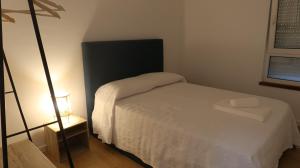 een kleine slaapkamer met een wit bed en een lamp bij Apartamento Renovado no Centro da Cidade - Casa4 in Coimbra