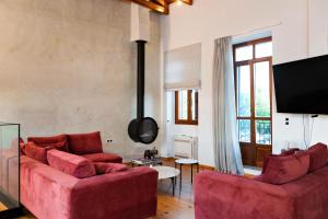 a living room with two red couches and a tv at Luminous Luxury Apartment in Chania