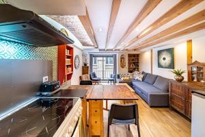 eine Küche und ein Wohnzimmer mit einem Sofa und einem Tisch in der Unterkunft Le petit Crequi- appartement atypique 2 pers- Foch in Lyon