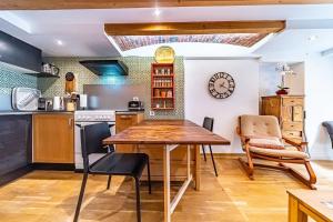 eine Küche und ein Esszimmer mit einem Holztisch und Stühlen in der Unterkunft Le petit Crequi- appartement atypique 2 pers- Foch in Lyon