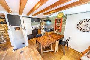 eine Küche mit einem Holztisch und einer Uhr an der Wand in der Unterkunft Le petit Crequi- appartement atypique 2 pers- Foch in Lyon