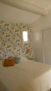 a bedroom with a bed with a flower patterned wall at Chambre d'hôte au cœur des Alpilles in Mouriès