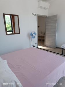 a bedroom with a white bed and a mirror at Appartamenti Garda -Luna & Sole - in Garda