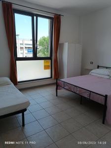 a bedroom with two beds and a large window at Appartamenti Garda -Luna & Sole - in Garda