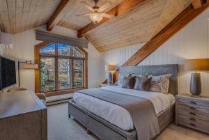 1 dormitorio con 1 cama grande y techo de madera en 1034- Ski In Ski Out Home on the Slopes en Steamboat Springs
