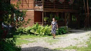 a woman in a dress walking down a dirt road at Cabana Victor in Sighetu Marmaţiei