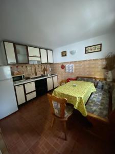 a kitchen with a table and a couch and a kitchen with a refrigerator at Casa Aura in Băile Herculane