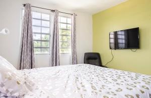 a bedroom with a bed and a flat screen tv at The Calle Retreat by the Airport & Beach in Carolina