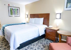 a hotel room with a large bed and a chair at Days Inn by Wyndham College Park Atlanta Airport South in Atlanta +24 photos