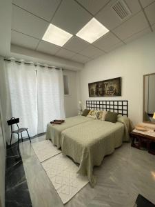 a bedroom with a large bed and a chair in it at Apto. Singular en la Mancha Banco de Inversiones in Argamasilla de Alba