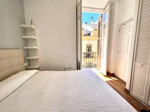a bedroom with a white bed and a window at Historic Center Cathedral in Málaga