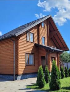 una casa de madera con techo de gambrel en Лазурний берег en Pulemets