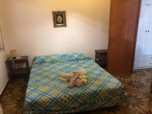 un orsacchiotto di peluche steso su un letto di Residence Enrico a Mondello