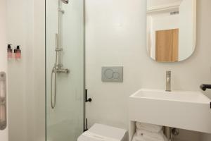 y baño con ducha, lavabo y espejo. en NŌSTOS Serifos, en Livadion