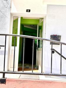 een open deur van een gebouw met een metalen leuning bij New-Romantic studio near the beach! in Paço de Arcos