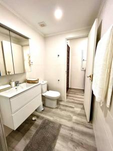 een witte badkamer met een toilet en een wastafel bij New-Romantic studio near the beach! in Paço de Arcos