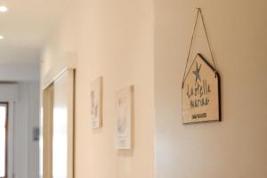 un cartello appeso a un muro in una stanza di Casa Stella Marina a Pozzallo