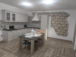 eine Küche mit einem Tisch mit Stühlen und einer Steinmauer in der Unterkunft La casa di Rubin in Carloforte