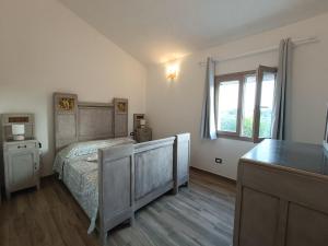 Schlafzimmer mit einem Bett und einem Fenster in der Unterkunft La casa di Rubin in Carloforte