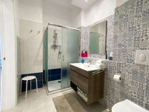 bagno con doccia, lavandino e specchio di Casa Stella Marina a Pozzallo