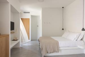 1 dormitorio blanco con 1 cama y TV en NŌSTOS Serifos, en Livadion