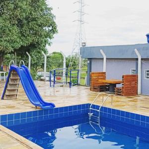 a pool with a slide and a playground at Chacara Tropicalia in Passos