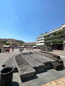 a group of benches in a courtyard with a building at MODERN APARTMENT 200M FROM ACROPOLIS 100Mbps NETFLIX in Athens