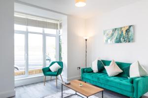 a living room with a green couch and a table at Luxury House in the Heart of Mumbles Village in The Mumbles