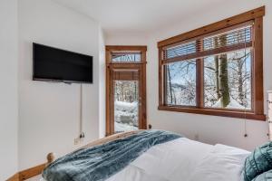 1 dormitorio con TV de pantalla plana en la pared en 1061- Spacious Mountain Townhouse with Garage Shared Hot Tub and Pool en Steamboat Springs