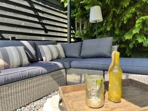 un sofá azul y una botella amarilla en una mesa en Luxe Natuurhuisje met jacuzzi en haard in Drenthe, ECHTEN, en Echten