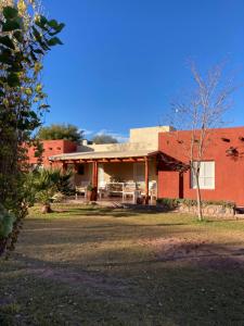 una casa di mattoni rossi con un albero di fronte di Cabaña Chañares de Banda Florida - Ama a Villa Unión