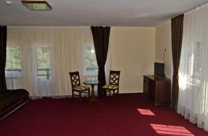 a living room with a table and chairs and windows at Stupari in Shaian