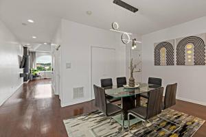 a dining room with a glass table and black chairs at The Penthouse, Lux stay near Downtown, UofC & Lake in Chicago