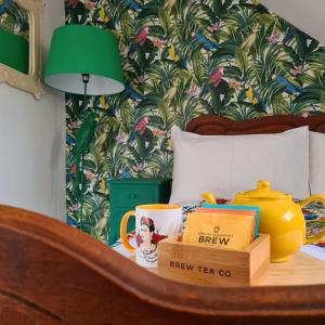 een slaapkamer met een bed met een groene lamp en een tafel met boeken bij Frida's Cottage Whitby in Whitby