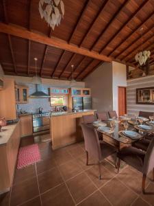 uma sala de jantar e cozinha com mesa e cadeiras em Pousada Aurora na Praia do Rosa