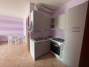 une cuisine avec des appareils électroménagers blancs et une table avec des chaises dans l'établissement Appartamento vista Lago d'Iseo, à Sulzano