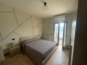 - une chambre avec un grand lit et une fenêtre dans l'établissement Appartamento vista Lago d'Iseo, à Sulzano